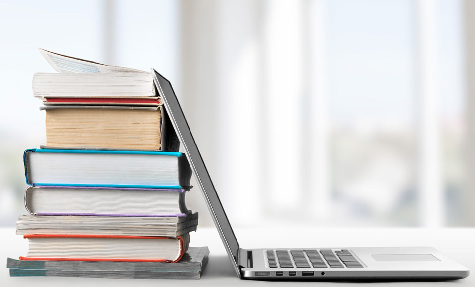 ordinateur portable et pile de livres